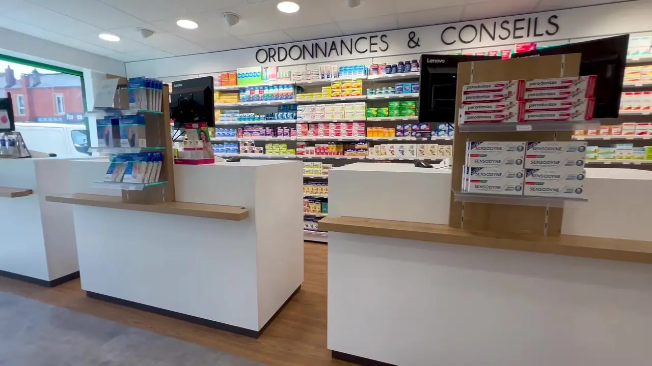 L'officine vue de face, les comptoirs et le mur des ordonnances
